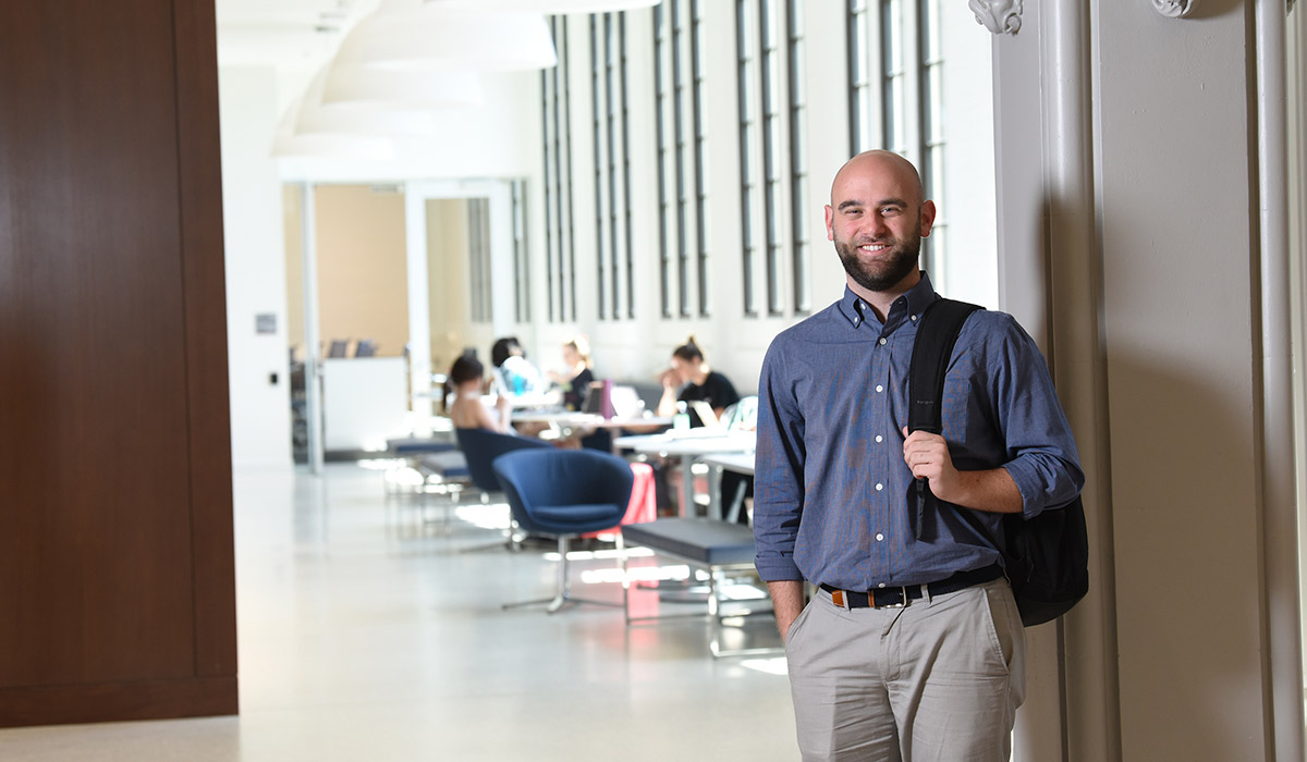 Student Justin Smith smiling in a lounge of the Busch School of Business.