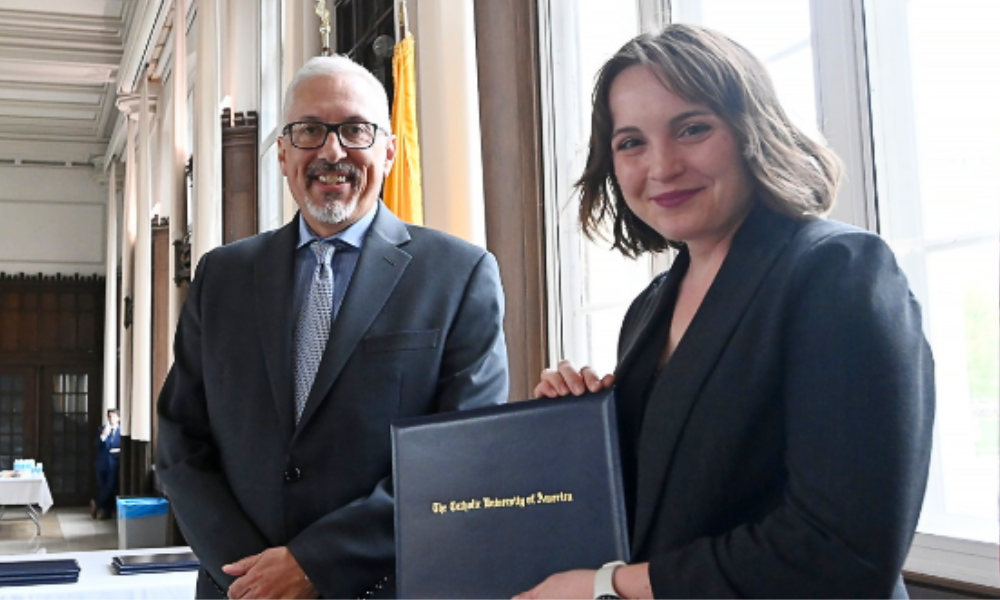 Student Chloe Masaitis smiling as she holds her Research Day Presentation Award.